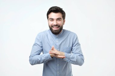 Onun önünde ellerini ovuşturarak kurnaz bir ifade ile sakallı bir İspanyol erkek öğrenci