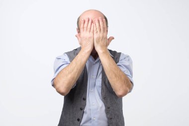 Kel adam yüzünü iki el ile kaplı