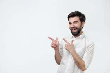 Mutlu güzel gülümsüyor ve bir kenara eliyle işaret kameraya, arayan adam sakallı.