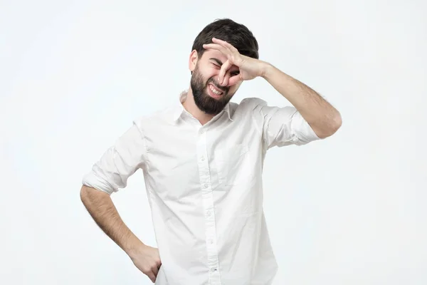 Missnöjd brunet man pluggar näsa som luktar något stinker och obehagliga. — Stockfoto