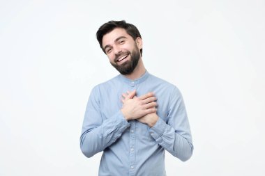 Neşeli İspanyol adam gülümsüyor ne mutlu ki, elleri göğsünde duruyor, onun olumlu duygular ifade eder.
