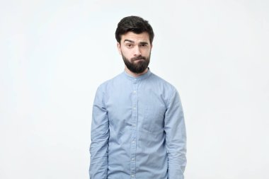 Şüpheli sakallı genç İspanyol adam güvensizlik ile seyir.