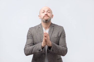 Lütfen yardım et. Sakallı olgun adam bir yardıma ihtiyacım var. Gri arka plan üzerinde atış studio izole