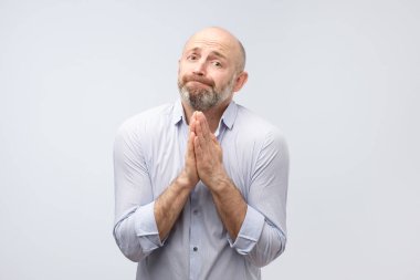 Lütfen yardım et. Sakallı olgun adam bir yardıma ihtiyacım var. Gri arka plan üzerinde atış studio izole