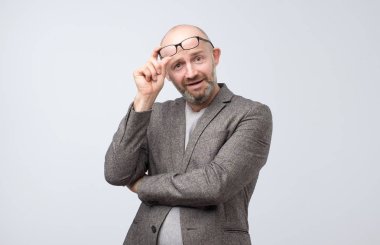 Gözlük kamera üzerinde görünen meraklı olgun adam portresi. Negatif yüz duygu