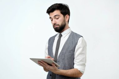 Dalgın genç yakışıklı adam internet sörf onun dijital tablet kullanma