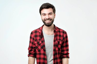 Genç yakışıklı adam gülüyor ve kameraya büyük bir sırıtma ile seyir.