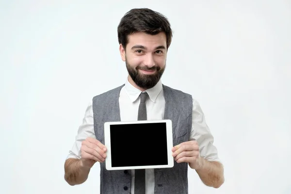 Латиноамериканец с черной бородой показывает планшетный компьютер с пустым экраном — стоковое фото