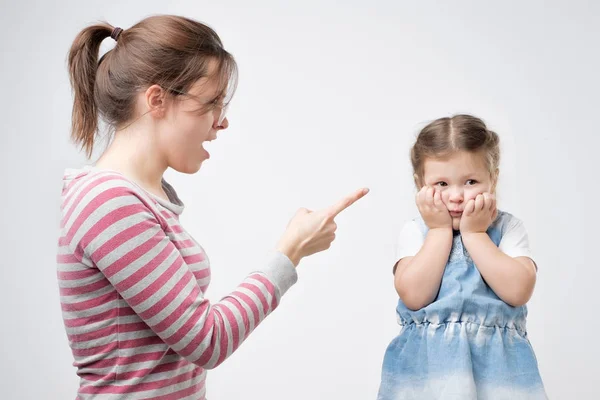 年轻的母亲骂她的女儿。小女孩用双手捂住脸. — 图库照片