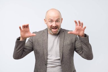 Bir kaplan olmak gibi davranarak yakışıklı orta yaş giyen takım elbise.