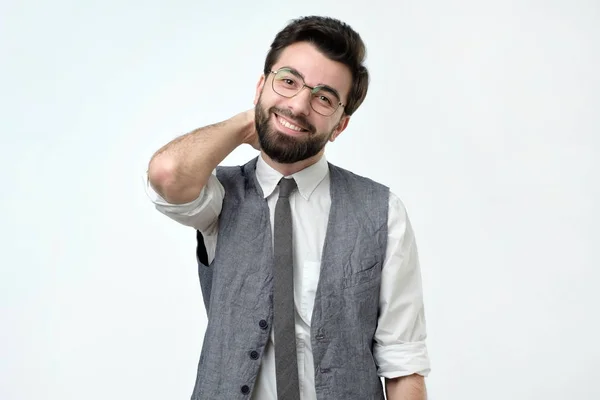 Homem hispânico com cerdas segurando a mão na nuca e sorrindo . — Fotografia de Stock