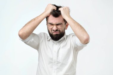 İş yerinde bir tükenmişlik sahip öfke için saçını çekerek öfkeli genç işadamı