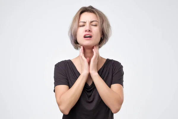 Mooie jonge vrouw in zwarte t-shirt heeft een zere keel — Stockfoto