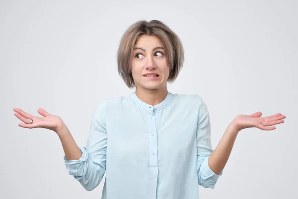 Woman in blue clothes shrugging her shoulders, expressing doubt, uncertainty or indifference — Stock Photo, Image