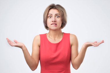 Şüpheli, belirsizlik veya ilgisizlik ifade kadın onun omuzlarında shrugging Mavi giysili