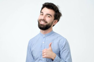 Başparmak gösterilmesini ve kameraya bakarak gülümseyen adam. Yakışıklı olan bir şey reklam.