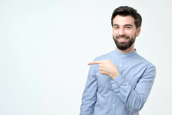 Elegante bonito jovem hispânico homem apontando para o lado . — Fotografia de Stock