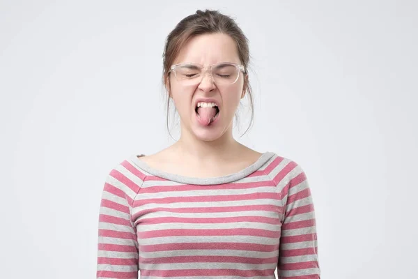Junge Europäerin zeigt Zunge, die frech ist. — Stockfoto