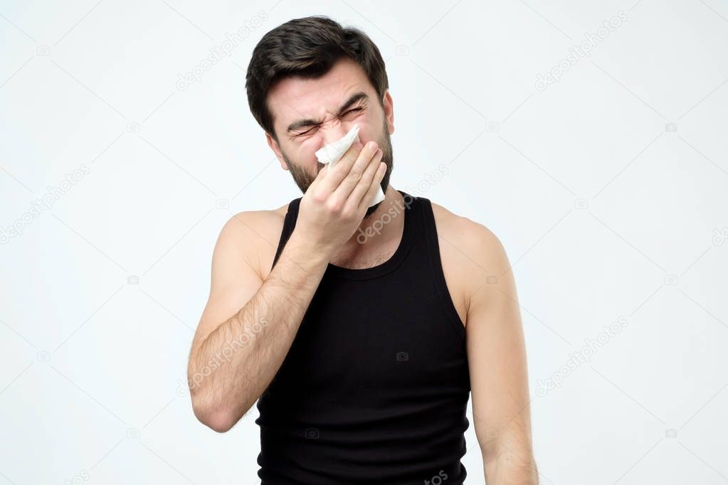 Man has running nose, rubs nose with handkerchief, being ill, caught cold