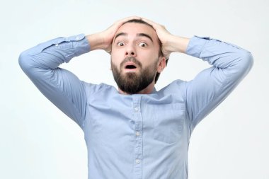 Holding adam açık ağızlı kameraya bakarak kafasına eller.