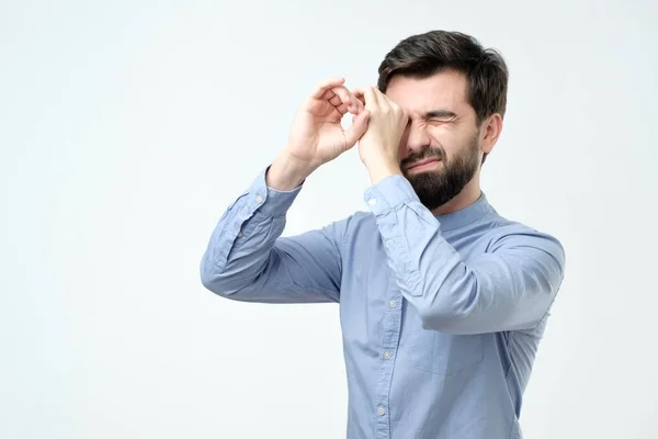 Bell'uomo che si tiene le mani agli occhi come se guardasse attraverso gli occhiali da spia — Foto Stock