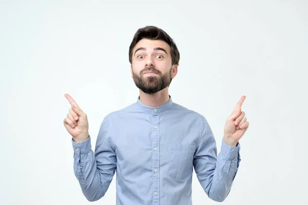 Homem de camisa azul apontando para cima com o dedo isolado em fundo cinza . — Fotografia de Stock