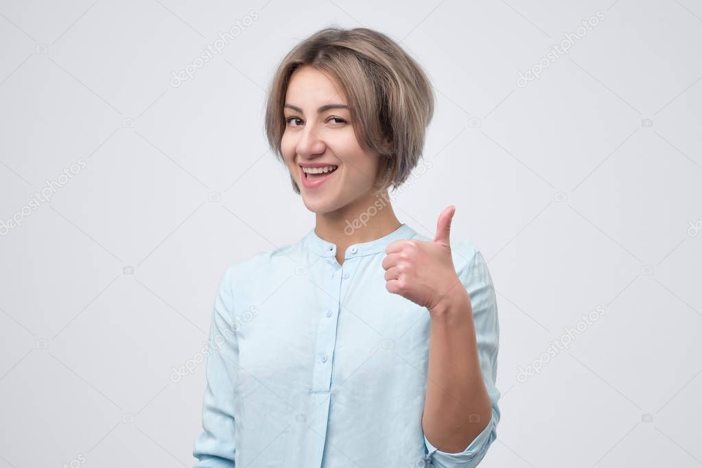 Beautiful young success woman giving thumbs up