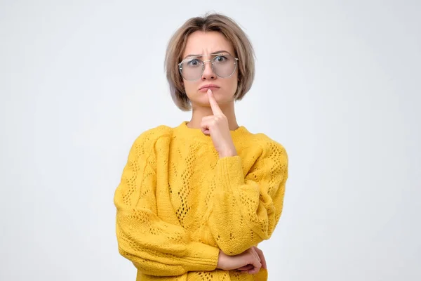 かなりカジュアルな思考決断をしようとカメラを見てメガネを黄色いセーターの女性 — ストック写真