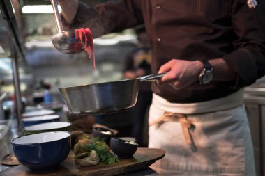 Erkek cook restoranda leziz yemeklerin servis yapın. Çorba yemek hazır.