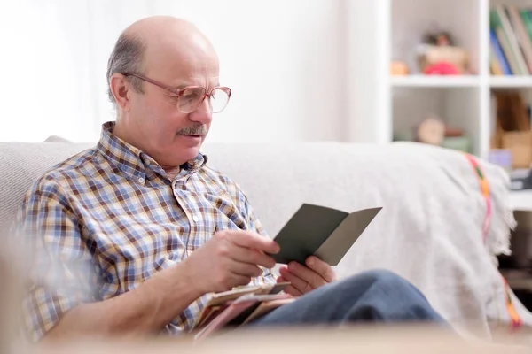 Hombre Mayor Gafas Leyendo Libro Sofá Sentado Sala Estar —  Fotos de Stock