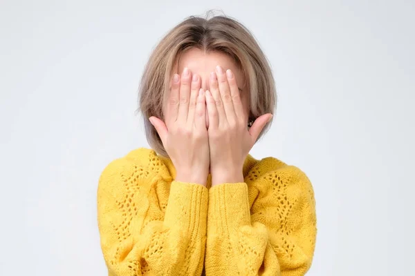 Jovem Mulher Europeia Suéter Amarelo Esconde Seu Rosto Foto Estúdio — Fotografia de Stock