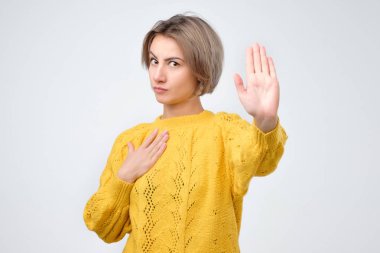 Sarı kazak yapma dur jestle onun Palm'da bir graybackground genç kadın