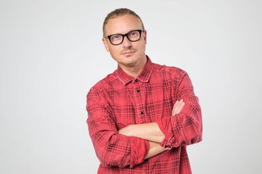 Gözlük kamera beyaz arka plan karşı dururken bakarak kırmızı gömlek giymiş emin olgun adam.