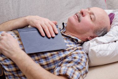 Komuta sizde bir kitapla kanepede uyuyor