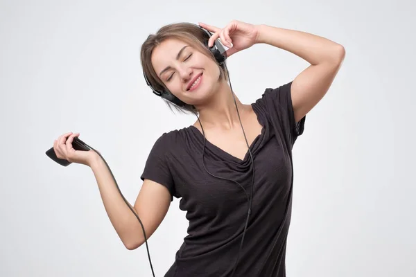 Mujer europea alegre escuchando música en el teléfono móvil . — Foto de Stock