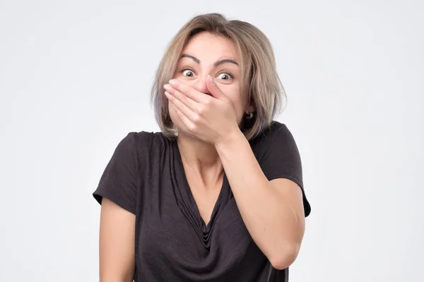 Mladá žena Gigglesovi radostně, pokrývá ústa, jak se snaží zastavit smích — Stock fotografie