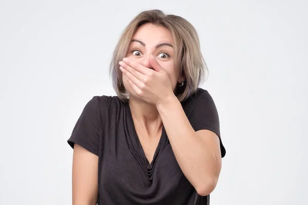 Junges Weibchen kichert fröhlich, bedeckt den Mund, als sie aufhört zu lachen — Stockfoto