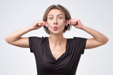 güzel genç kadın kendini kulaklarından çekerek