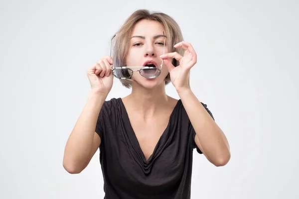 Mujer limpiando sus gafas limpiando el polvo . — Foto de Stock