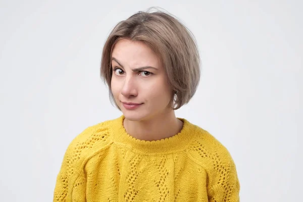 Pretty young caucasian woman in yellow sweater with a curious expression — Stock Photo, Image