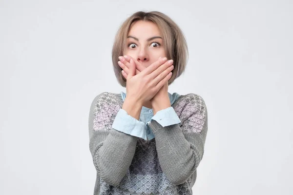 Überraschte Frau bedeckt Mund mit Hand und starrt in Kamera — Stockfoto