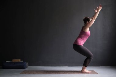 Pratik yoga, sandalye egzersiz, Utkatasana poz yapmak, çalışma dışarı bir kadın.