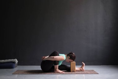 Genç kadın pratik yoga asana amarichyasana kapalı