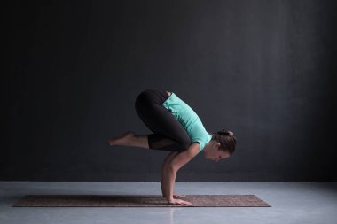 Pratik yoga, Vinç egzersiz, Bakasana poz yapmak, çalışma dışarı genç kadın.