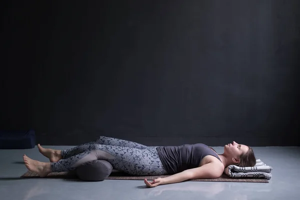 Donna che lavora fuori, facendo esercizio di yoga sul pavimento in legno, sdraiato a Shavasana — Foto Stock