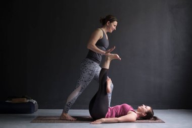 Kız uzanmış el başparmağı poz, supta padangusthasana için yapmak için yardımcı koç
