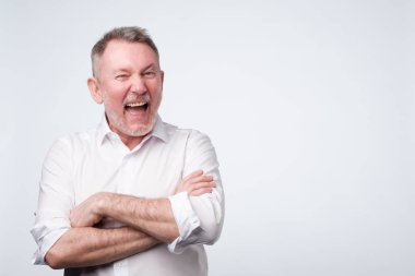 Yaşlı adam beyaz gömlek daimi stüdyoda gülümseyen.