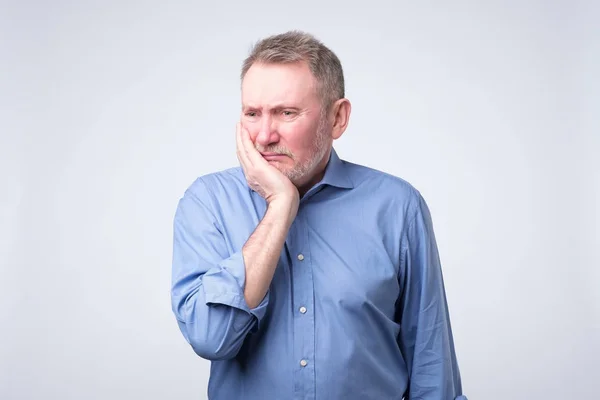 Homem sênior de camisa azul sofrendo dor de dente — Fotografia de Stock