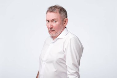 Komuta sizde çatık ve gözlerini kısarak, güvensizlik veya şüphe gösterilen Kırmızı gömlekli