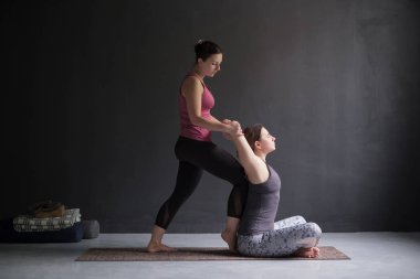 omuz ve göğüs yoga asana yaparken açmak için onun arkadaşı yardımcı kadın,
